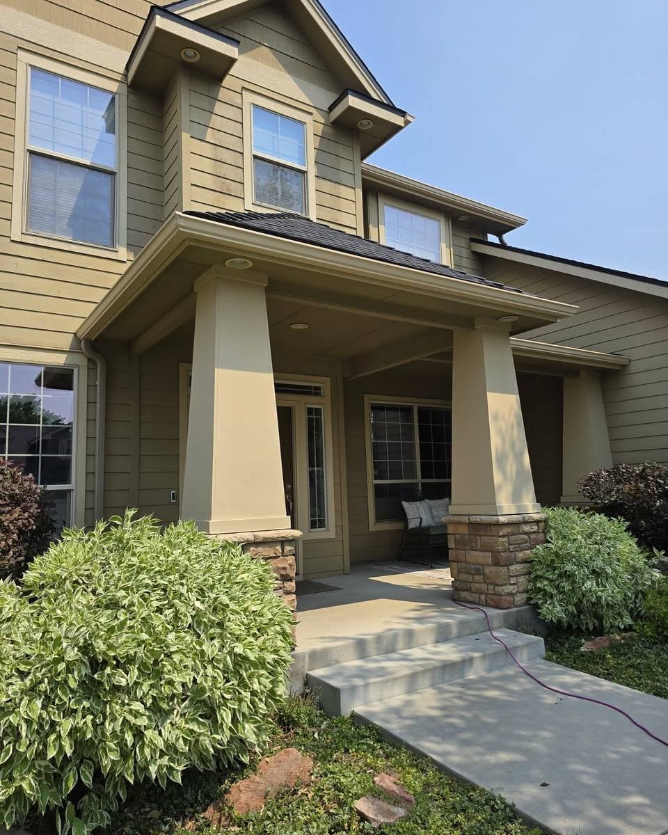 Finished seamless gutter and downspout on the covered entry of an olive green Treasure Valley home